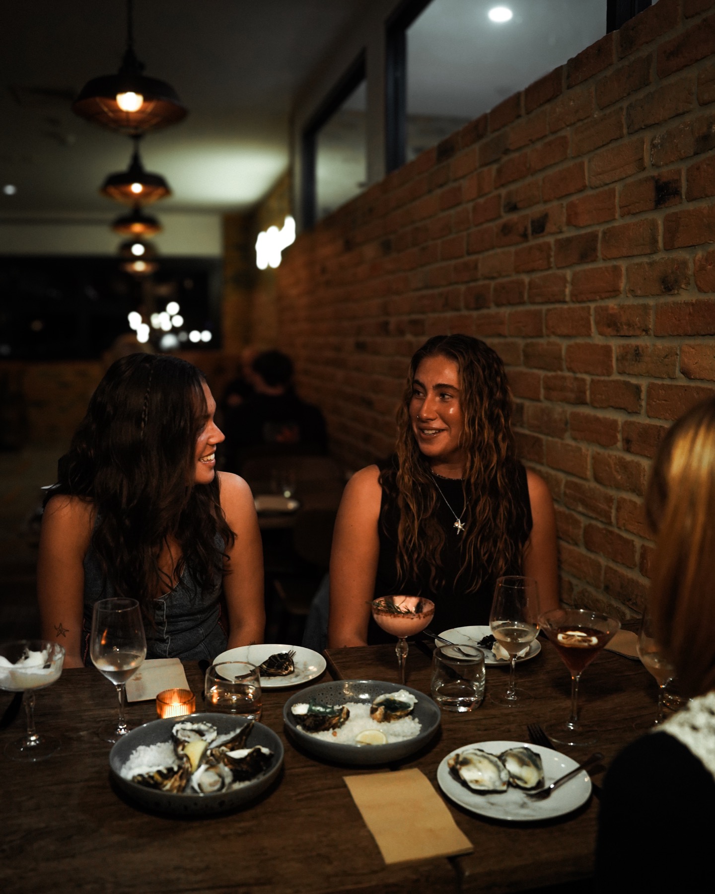 Friends enjoying oysters and drinks at The Wharf